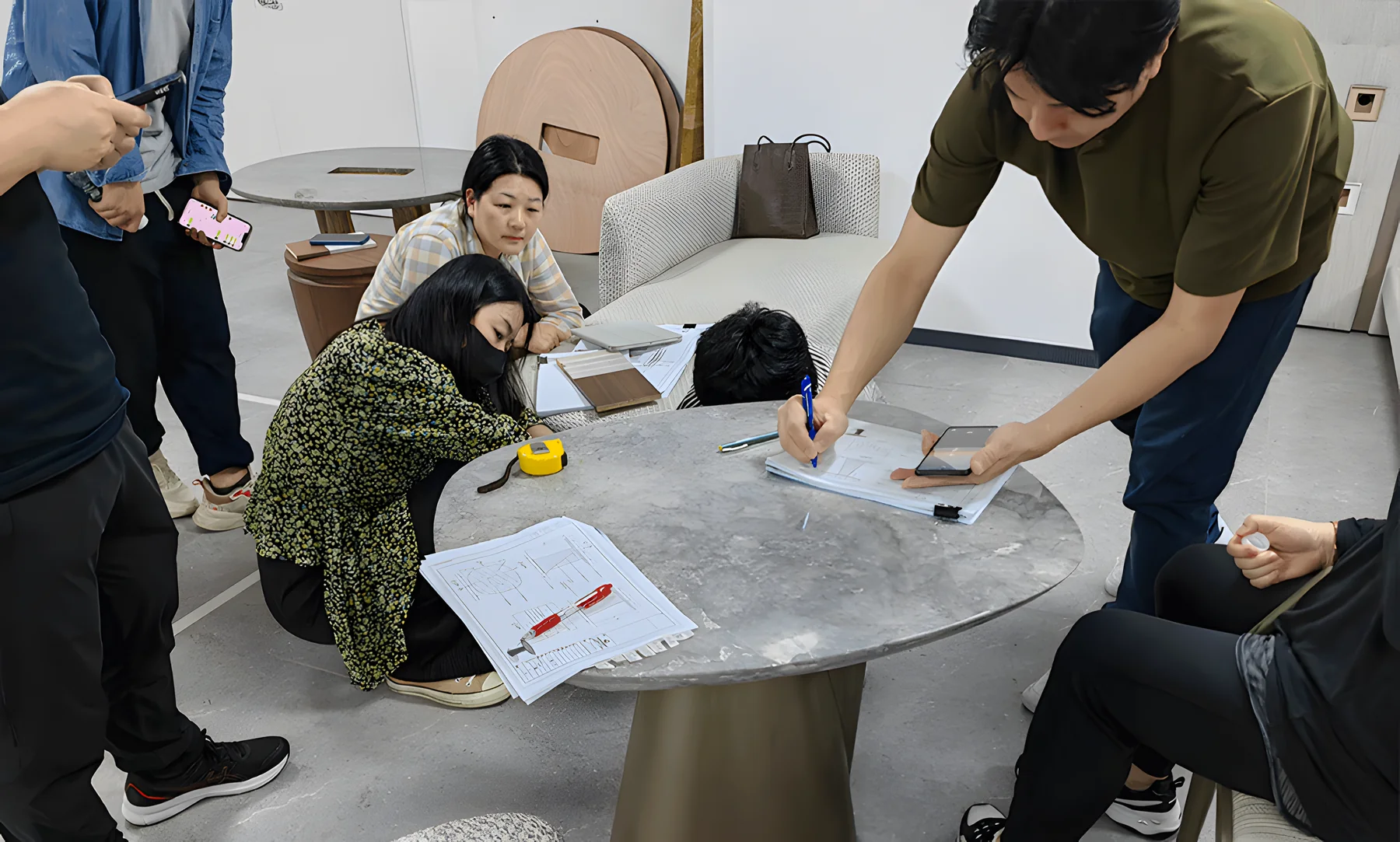 A team measuring and reviewing a table sample